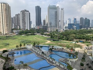 Un ensemble immobilier composé d’immeubles de grande hauteur, doté de plusieurs piscines et d’un espace paysager.