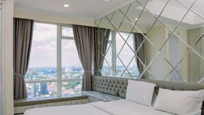 Une chambre avec un grand lit, une vue sur la ville par la fenêtre et un miroir décoratif.
