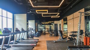 A gym with treadmills, weight machines, and a mirrored wall. - Fabulous 1BR Apartment at The Newton Ciputra World 2 (Jakarta)