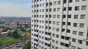 A high-rise building with multiple balconies and air conditioning units.