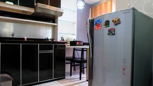 A kitchen with a refrigerator, cabinets, and a countertop.