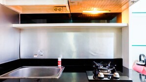 A modern kitchen with a stainless steel sink, a gas stove, and a range hood.