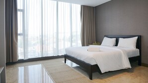 Ett modernt hotellrum med en stor säng, utsikt över staden genom tunna gardiner och ett golv av marmor.