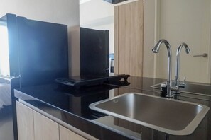 Fridge, stovetop, cookware/dishes/utensils - Restful Studio Apartment at Orchard Supermall Mansion (Surabaya)