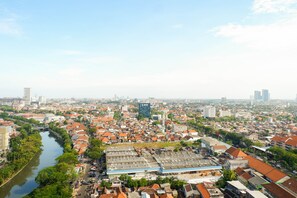 A cityscape with a river, dense residential buildings, and a large industrial area with flat-roofed structures.