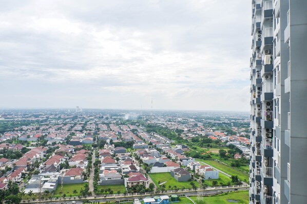 A residential area with a mix of single-family homes and apartment buildings, featuring a variety of roof colors and some greenery. - Best Value 1BR Apartment Connected to Mall at Anderson Supermall Mansion (Surabaya)