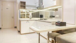 Une cuisine moderne dotée d’un grand îlot central, d’appareils électroménagers intégrés et d’un grand miroir.