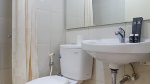 A bathroom with a toilet, sink, and shower curtain. - Modern Luxurious Studio Apartment at Tanglin Tower Supermall Mansion (Surabaya)
