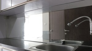 A modern kitchen with a stainless steel sink, a faucet, and a cabinet. - Nice View Studio Apartment at Harvard Jatinangor near IPDN (Cileunyi)