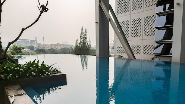 Una piscina infinita con vista despejada a un paisaje urbano.