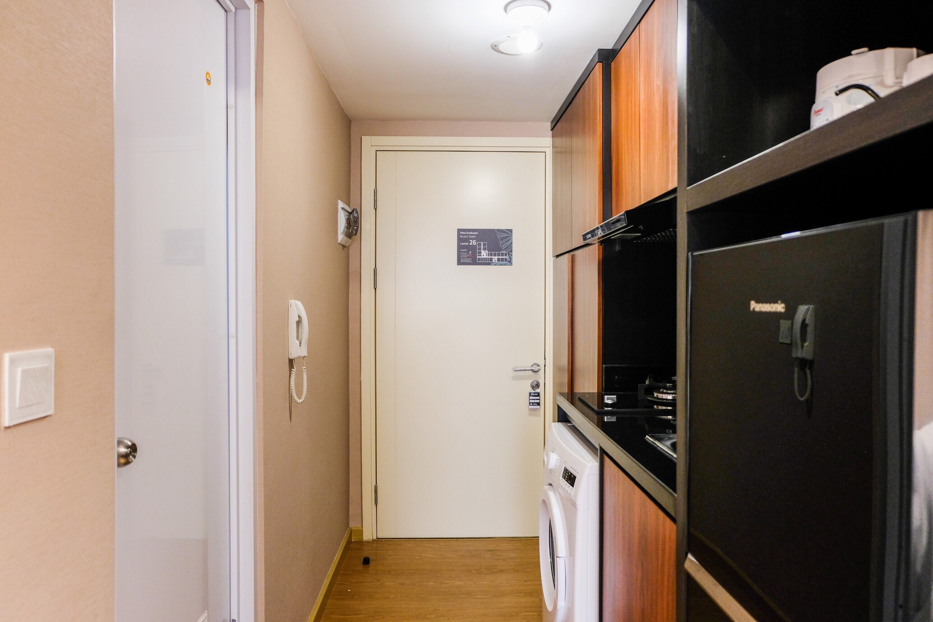 A narrow hallway with a washing machine, a refrigerator, and a cabinet.