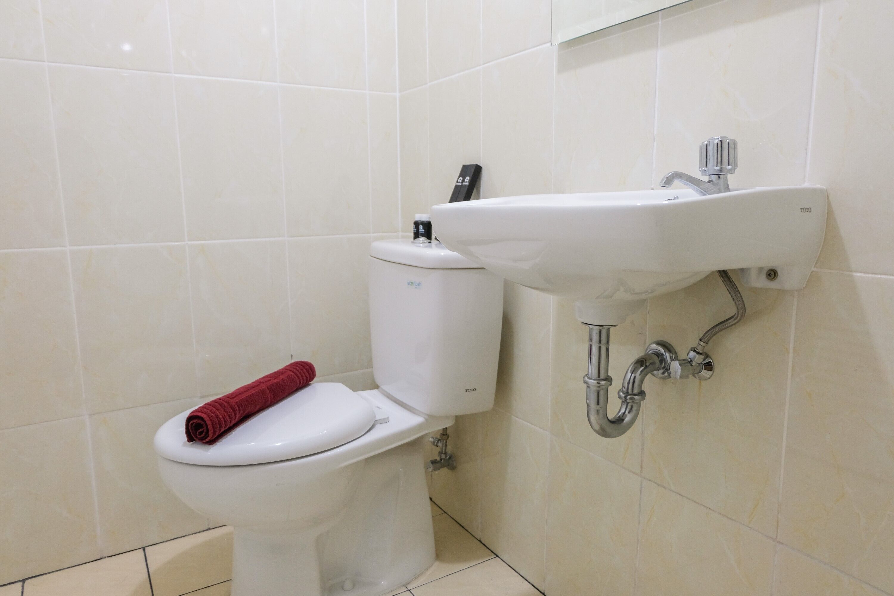 Une salle de bain avec des toilettes, un lavabo et une serviette.