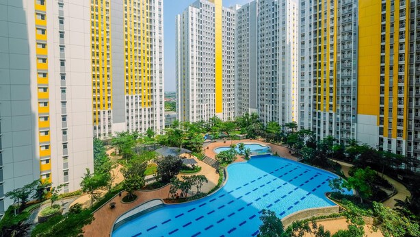 A high-rise residential building with multiple balconies and a swimming pool area. - Modern 2BR Apartment for 4 Pax at Springlake Summarecon (Bekasi)