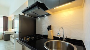 Una cocina moderna con un lavamanos de acero inoxidable, una estufa a gas y una campana extractora empotrada.