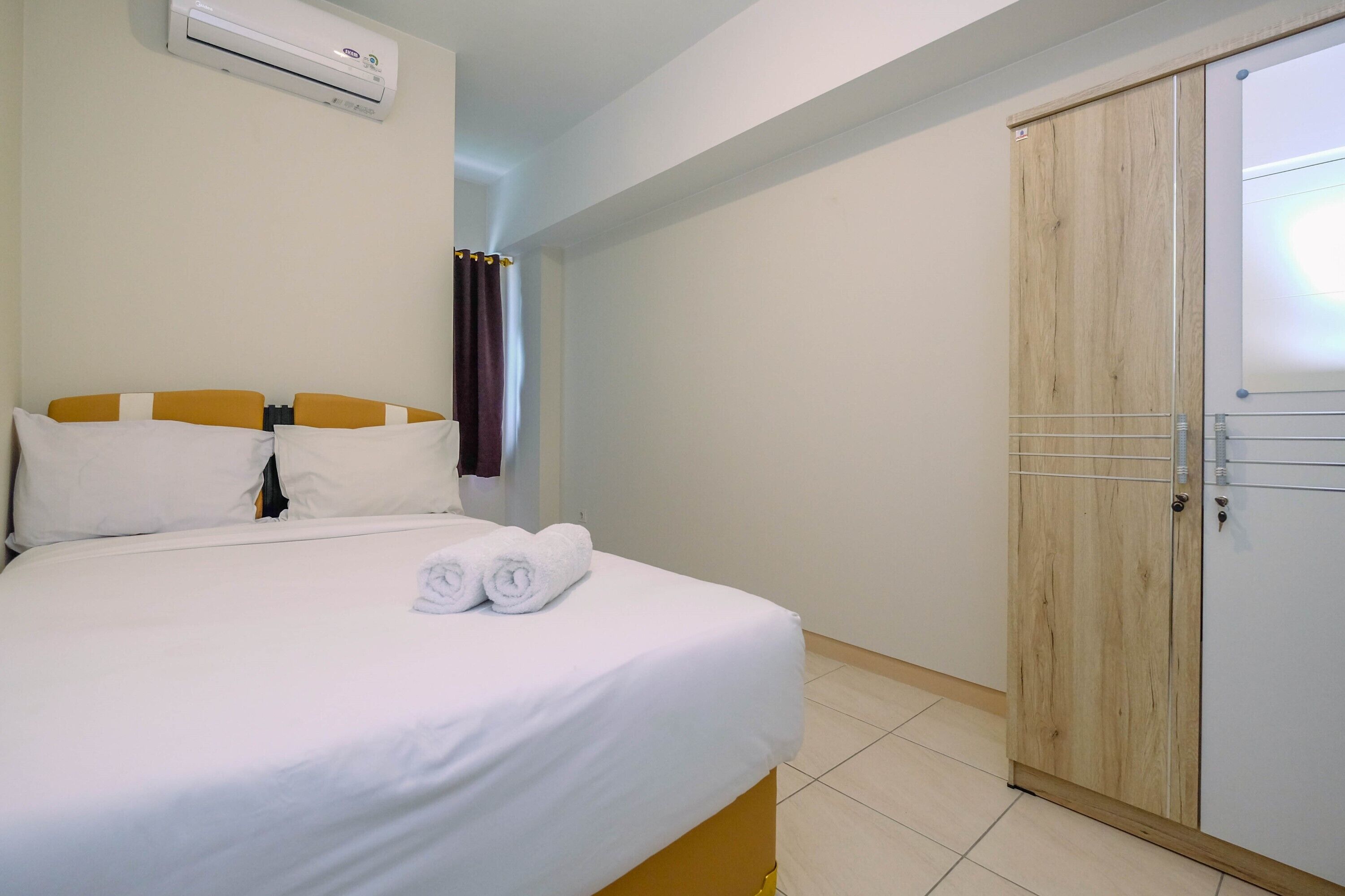 Una habitación de hotel con una cama, un armario y un equipo de aire acondicionado.