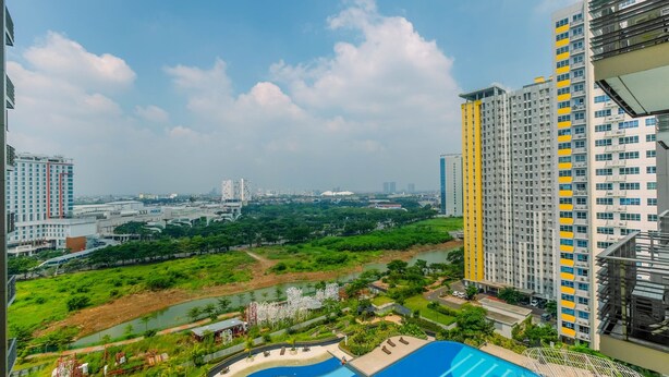 A high-rise building with a swimming pool and a river in the background.