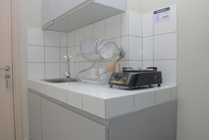 Room | Private kitchen | Fridge, stovetop, cookware/dishes/utensils - Elegant and Comfy Studio at Springlake Summarecon Apartment (Bekasi)