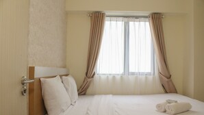 A hotel room with a bed, curtains, a window, and a door. - Comfort and Nice 2BR at Meikarta Apartment (Cikarang)