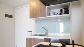 Uma cozinha compacta com fogão a gás, pia e armários de madeira.