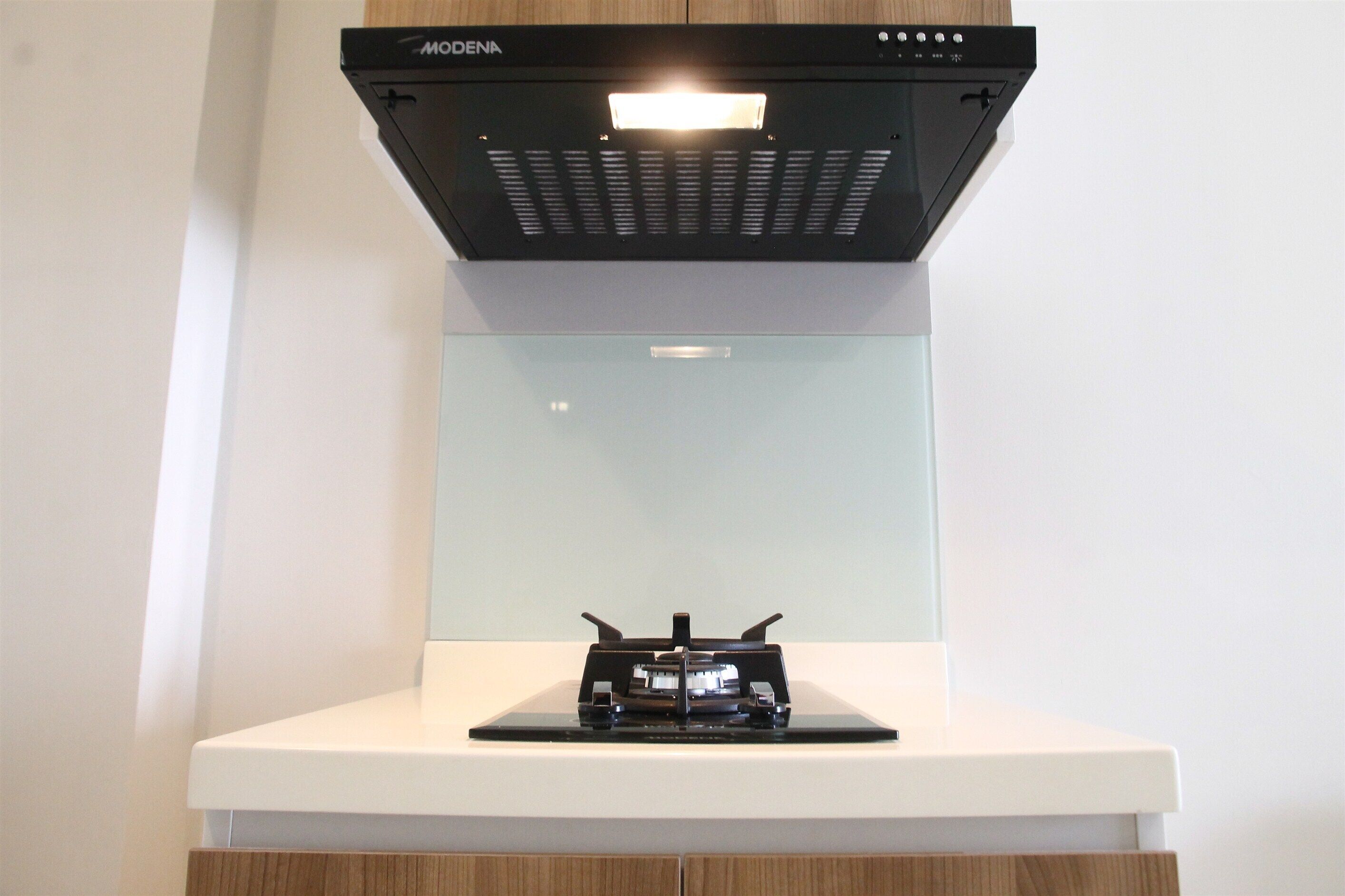 A modern kitchen with a built-in stove and a range hood above it.