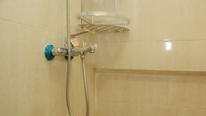 A shower with a handheld hose and a wall-mounted shelf. - Cozy and Relax 2BR at Meikarta Apartment (Cikarang)