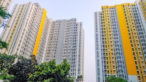 Un immeuble résidentiel de grande hauteur, doté de nombreux balcons et d’une façade agrémentée d’une couleur jaune.
