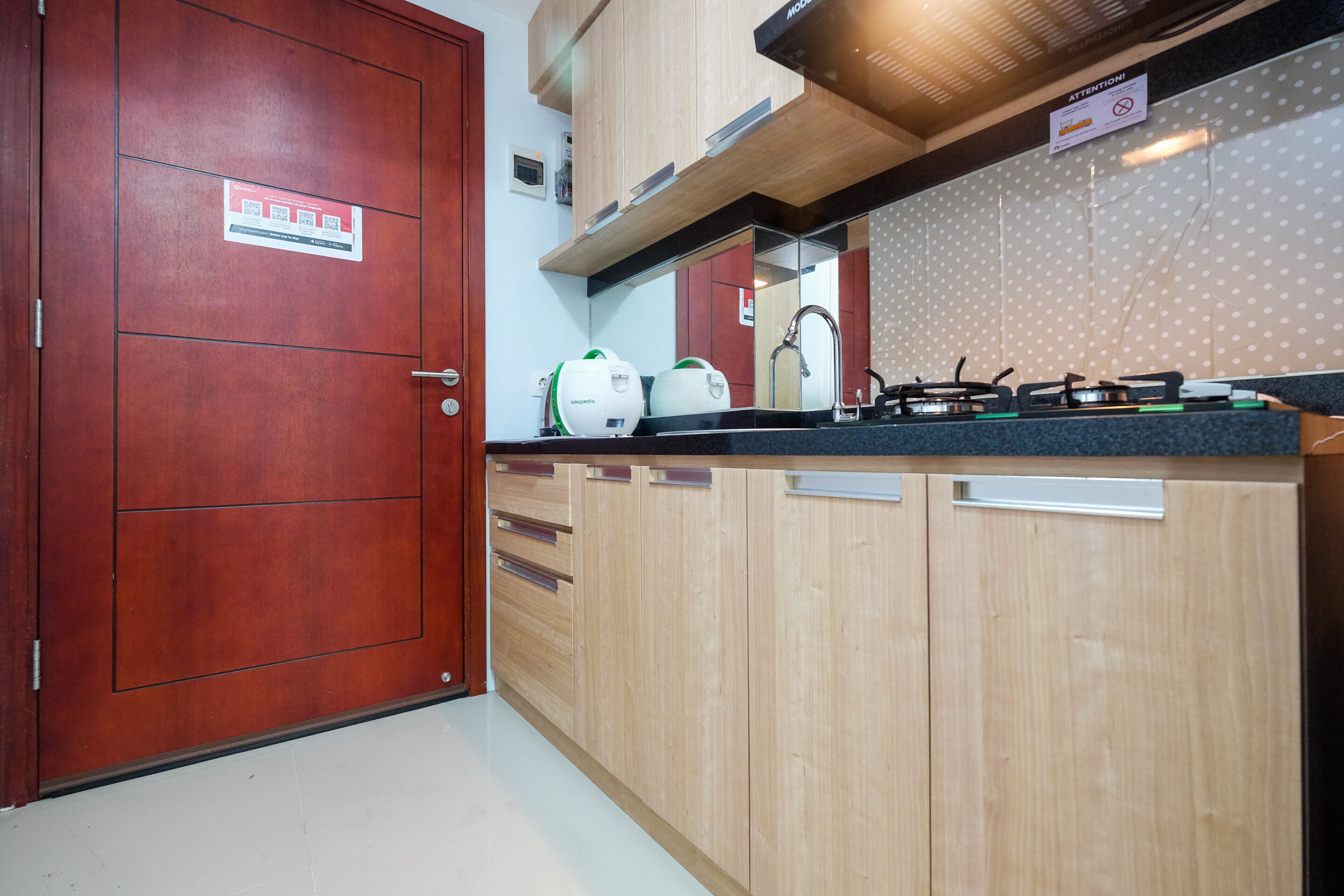 Una cocina con armarios de madera, un lavamanos de acero inoxidable y una estufa a gas.