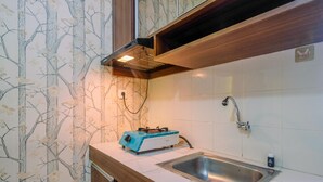 Una cocina con estufa a gas, lavamanos y salpicadero con diseño de árbol.