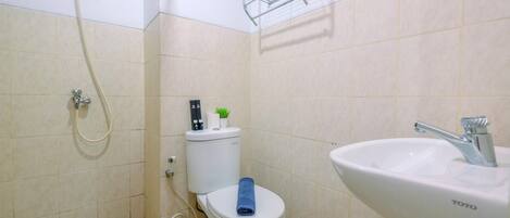 Un baño con inodoro, lavabo y ducha.