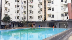 Piscina com o reflexo de um edifício alto.