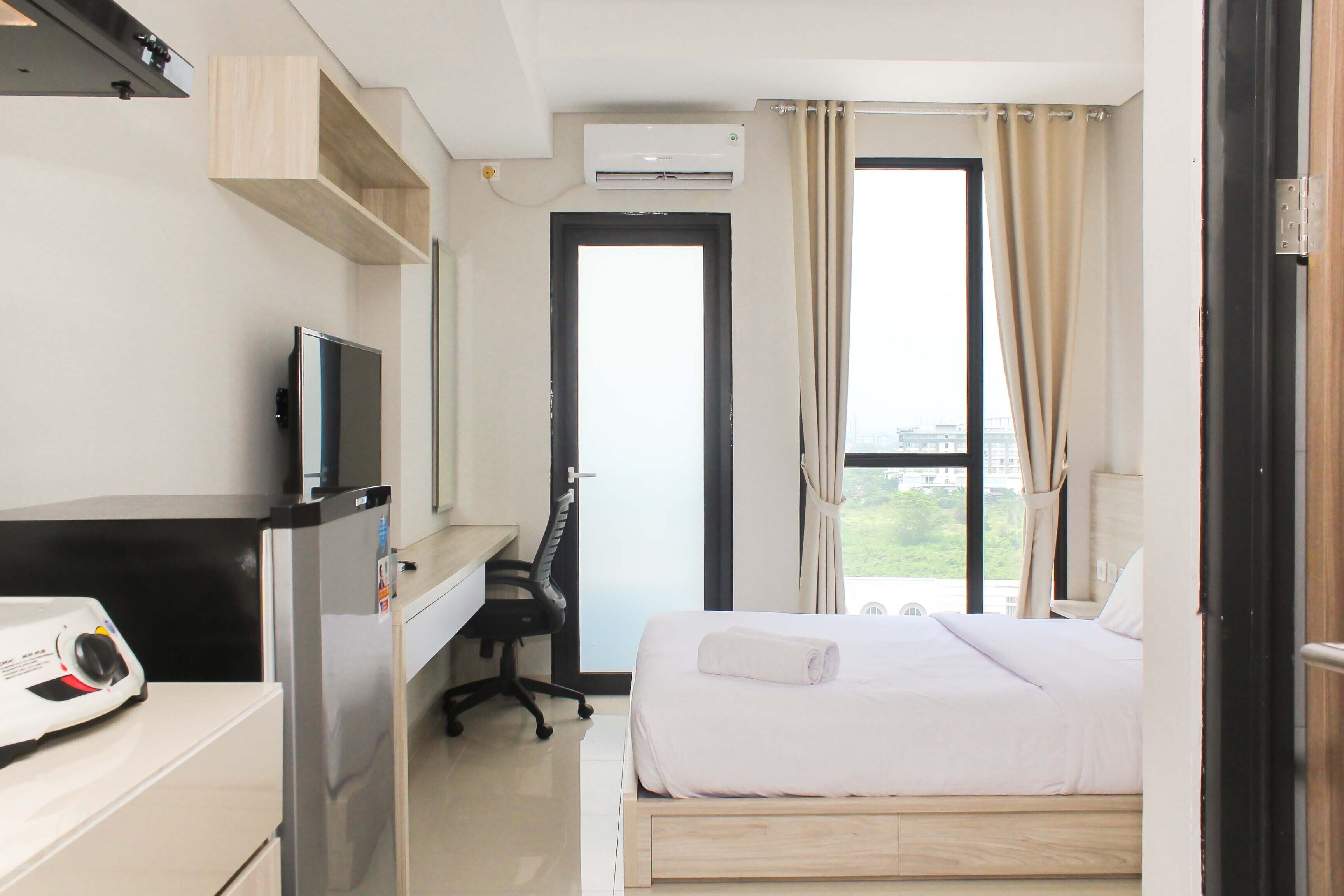 Une chambre d’hôtel équipée d’un lit, d’un bureau, d’une chaise, d’une télévision et d’un appareil de climatisation.