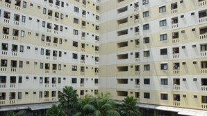 A multi-story residential building with balconies and a covered walkway. - Comfort Living 2BR at Kebagusan City Apartment (Jakarta)