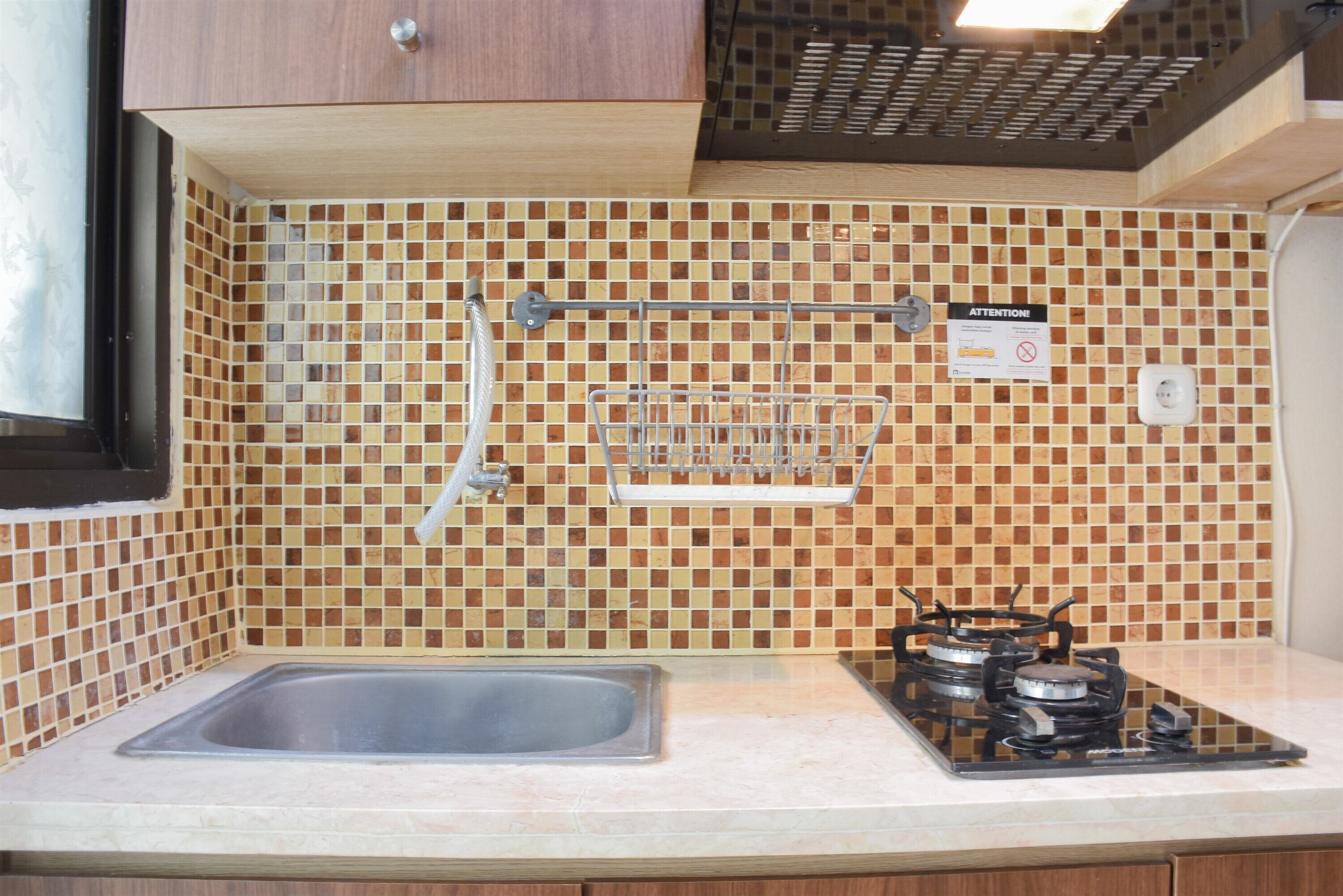 A kitchen with a sink, a stove, and a tiled backsplash.