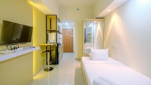 A hotel room with a bed, a TV, a desk, and a bathroom.