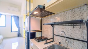 A modern kitchen with a built-in stove, a sink, and a window with curtains.