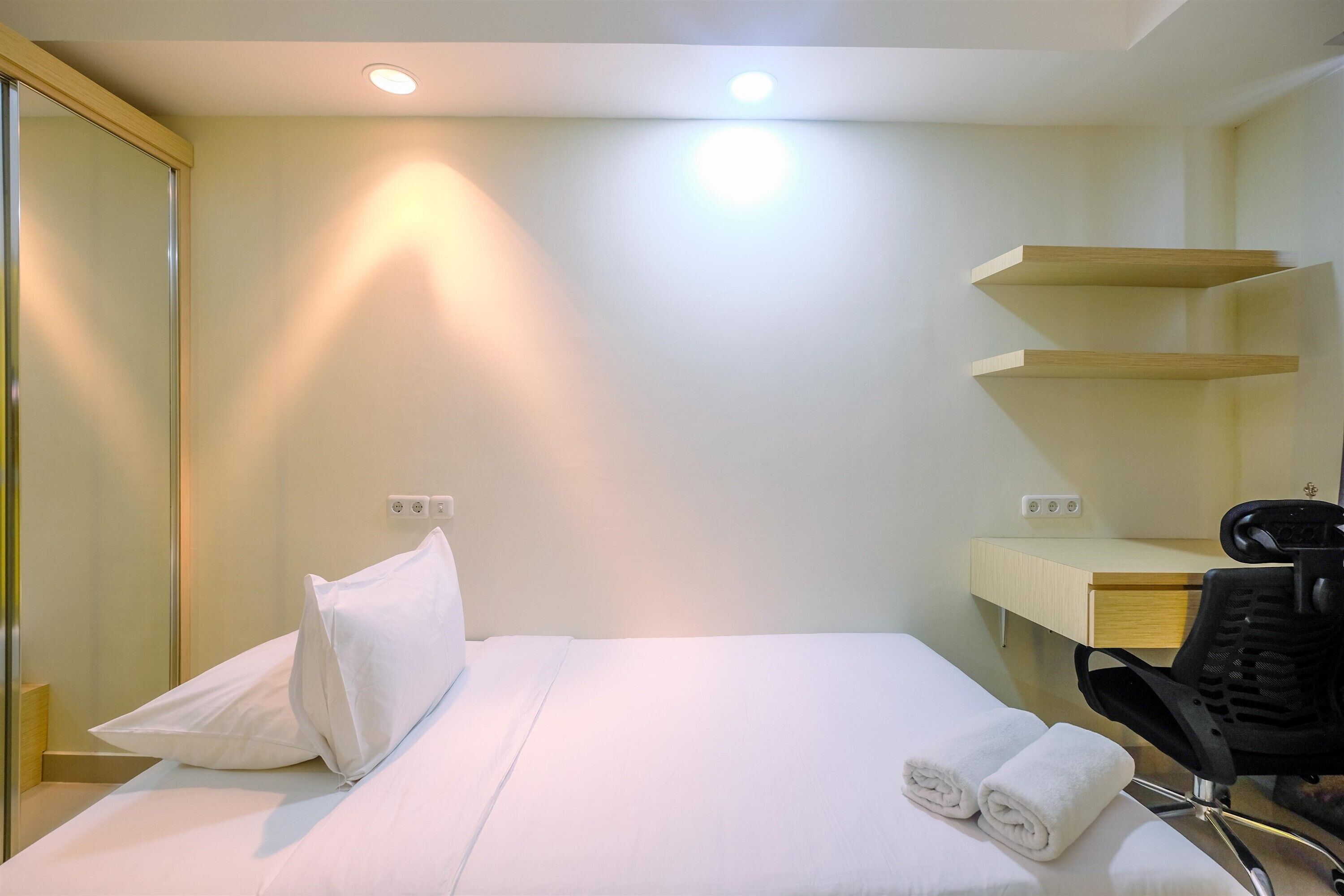 Una habitación de hotel con una cama, un escritorio y una silla.