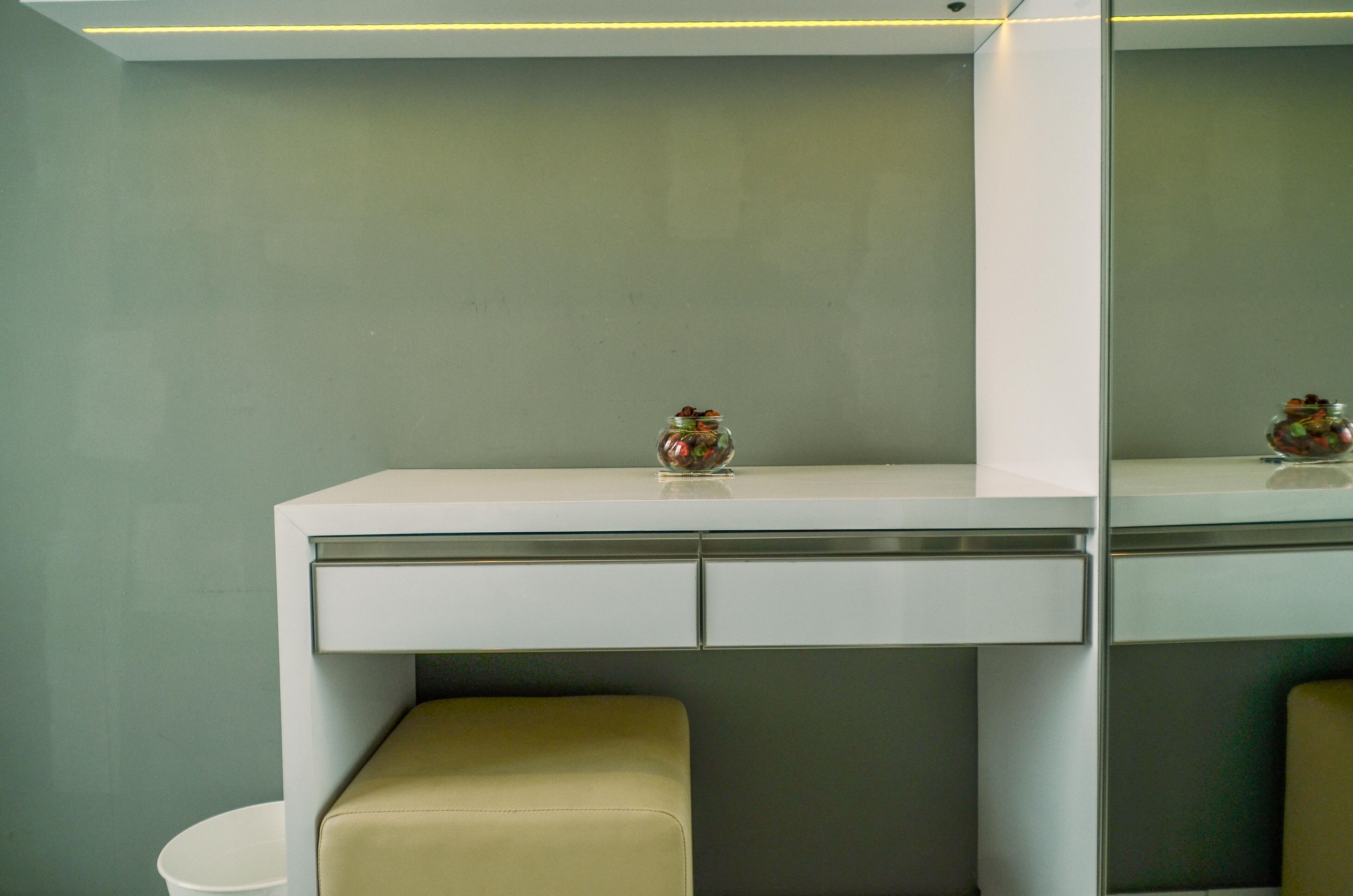 Une salle de bain moderne avec un meuble-lavabo blanc, un miroir et un petit vase décoratif.