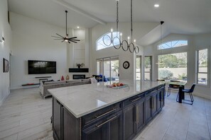 A spacious kitchen with a large island, dark cabinetry, and a modern chandelier. - Heated Pool Hot Tub, Hiking Near Trailheads Golf, Full Remodel, 5 Beds 3 Baths (Phoenix)