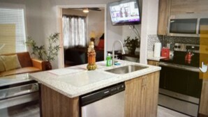 A kitchen with a dishwasher, a sink, a television mounted above the counter, and a microwave. - Best Apartment in Kissimmee ! 1 Free dinner ! (Kissimmee)