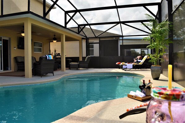 An indoor swimming pool with lounge chairs and a glass ceiling.