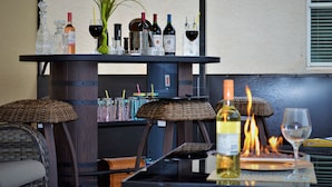 A bar area with a variety of bottles, glasses, and a fire feature. - Exquisite Destination Villas... Crystal location (Kissimmee)