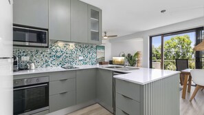 Enjoy cooking in this kitchen with a large island, sink, and microwave.