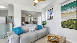 A modern living room with a sofa, a coffee table, and a painting.