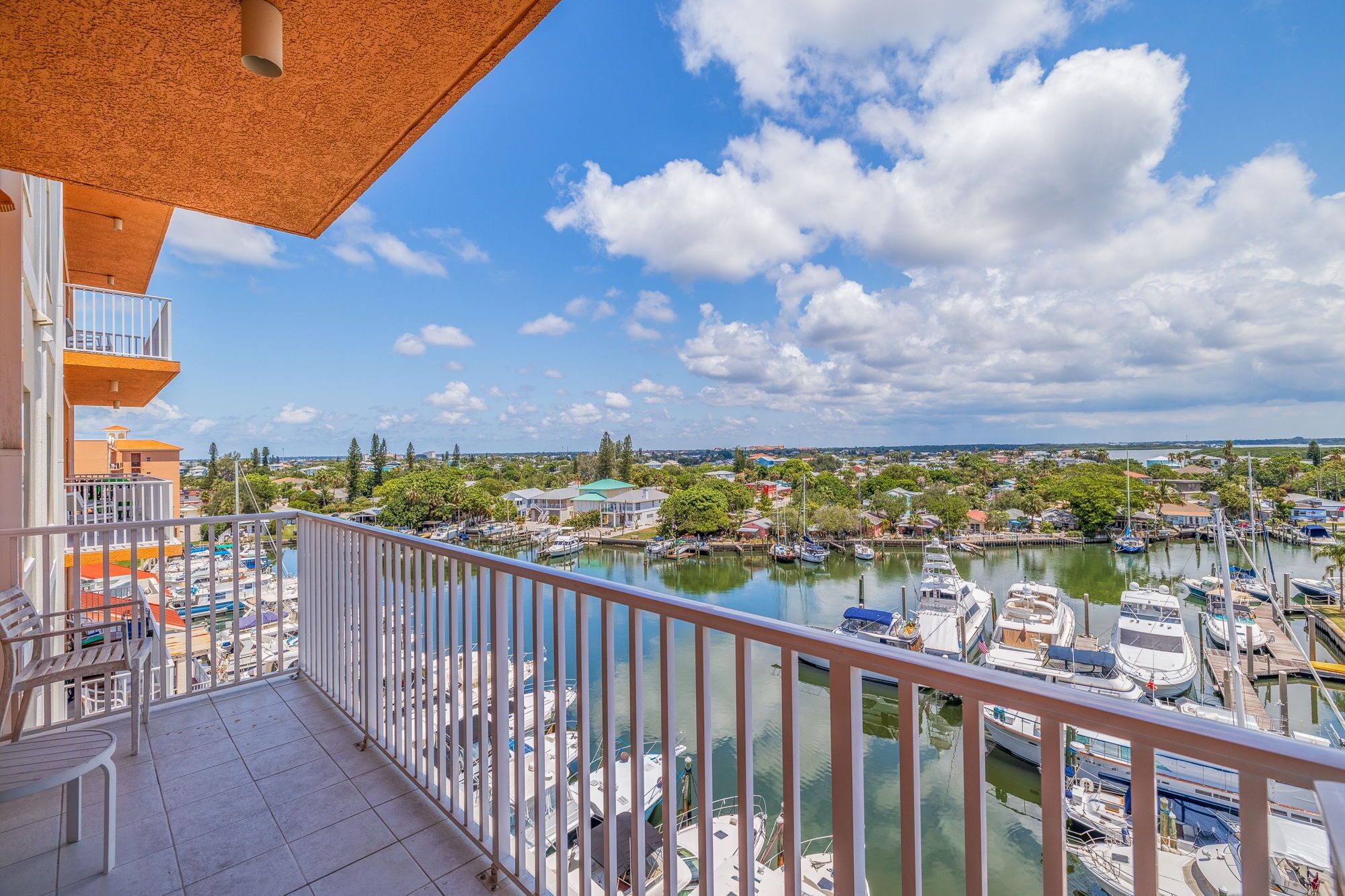 A balcony with a view of a marina and surrounding buildings.