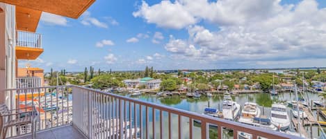 A balcony with a view of a marina and surrounding buildings.
