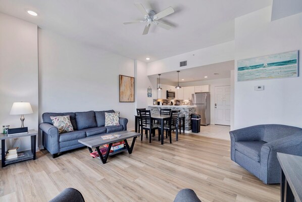A modern living room with a sofa, coffee table, and dining area.
