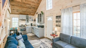 A cozy cabin interior with a living room, kitchen, and dining area.