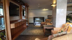 A spacious living area with a wooden entertainment unit, a flat-screen TV, and comfortable seating. - Beautiful Studio at Luana Waikiki Near Beach  (Honolulu)