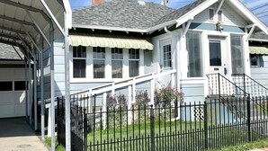A two-story house with a covered garage, a fenced yard, and a clear sky.