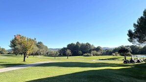 A golf course with a clear path, trees, and golf carts. - Apartment 4/5 persons Domaine et Golf international de Pont Royal (Mallemort)